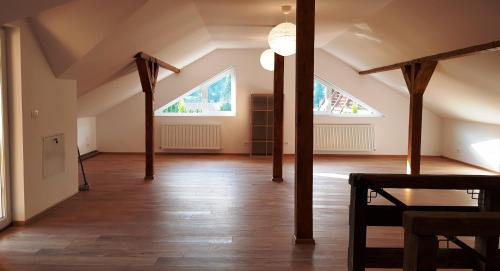 an attic room with wooden beams and two windows at Carpen View Residence in Săcele