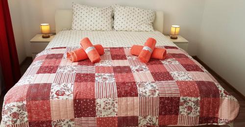 Schlafzimmer mit einem Bett mit einer roten und weißen Decke in der Unterkunft Carpen View Residence in Săcele