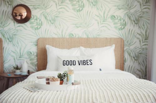 a bedroom with a bed with a good vibes sign on it at The June Motel in Picton