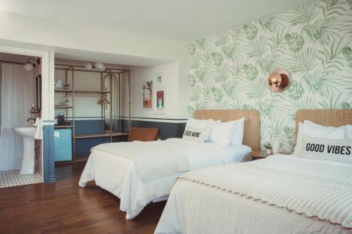 a hotel room with two beds and a kitchen at The June Motel, Prince Edward County in Picton