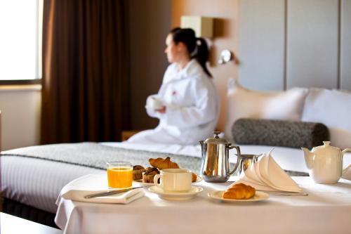 a woman in a hotel room with a table with food at Stamford Plaza Adelaide in Adelaide