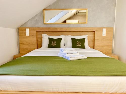 a bedroom with a large bed with a green blanket at Hotel Adore in Romanel-sur-Lausanne