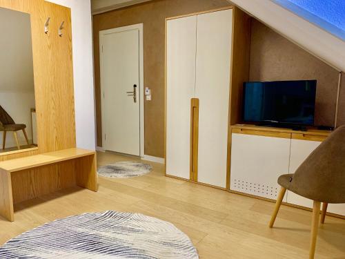 a living room with a tv and a living room with a couch at Hotel Adore in Romanel-sur-Lausanne
