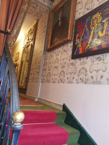 a staircase in a room with paintings on the walls at Le Kino Panorama in Vic-sur-Cère
