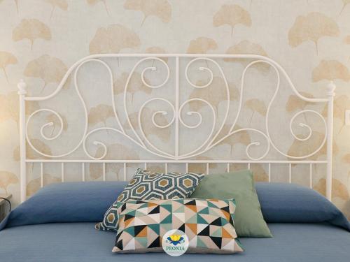 a bed with a white headboard in a bedroom at Peonia - appartamento in Laterza