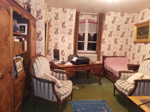 a room with a desk and chairs and a bed and a desk sidx sidx sidx at Le Kino Panorama in Vic-sur-Cère