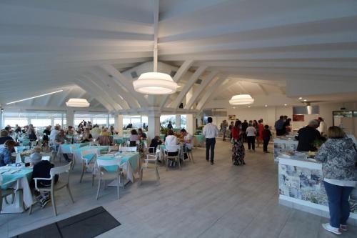 a group of people sitting at tables in a restaurant at BV Kalafiorita Resort in Zambrone