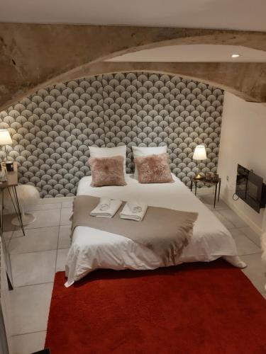 une chambre avec un grand lit avec une grande tête de lit dans l'établissement Souplex de la rue froide, à Caen