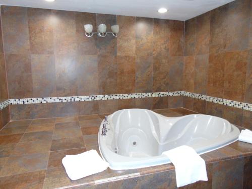 a bath tub in a bathroom with brown tiles at La Mirage in Monmouth Junction