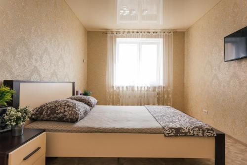 a bedroom with a large bed with a window at Luxury apart-hotel on Kharkovskaya neer Manufaktura in Sumy