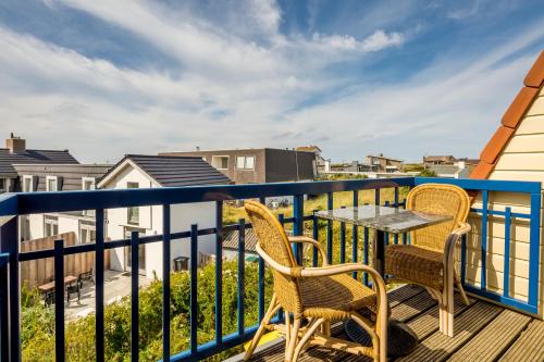 a patio with two chairs and a table on a balcony at Appartementen de Strandloper in Bergen aan Zee