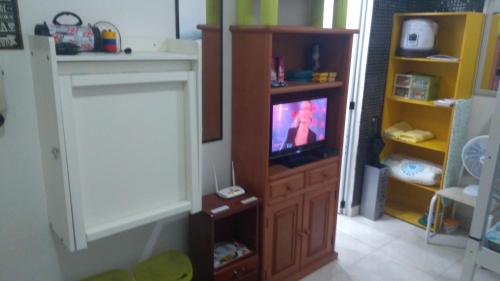 una sala de estar con TV en un centro de entretenimiento de madera en Flat Botafogo, en Río de Janeiro