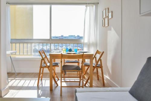 une salle à manger avec une table et des chaises et une fenêtre dans l'établissement Studio Carnon loggia au soleil et la mer à 2 pas, à Mauguio