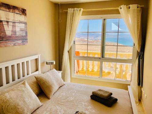 コスタ・カルマにあるSTAY SMART Fuerteventuraのベッドルーム1室(ベッド1台、大きな窓付)