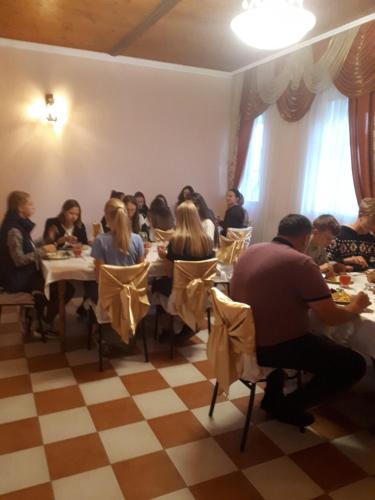 a group of people sitting at tables in a restaurant at Пані Анна in Kamianets-Podilskyi