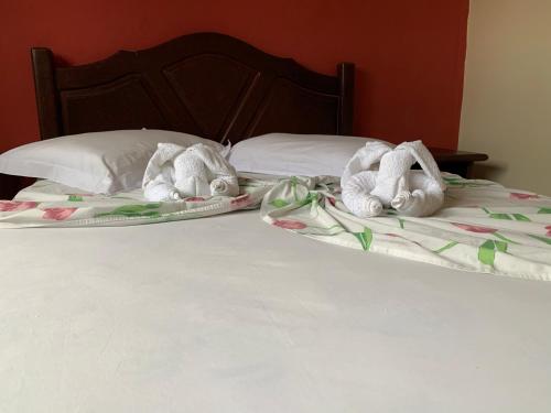 two stuffed animals are laying on a bed at Center Hotel in Imbé