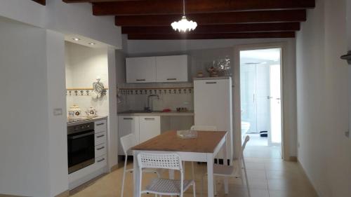 La cuisine est équipée d'une table, de chaises et d'un réfrigérateur. dans l'établissement ALLOGGI DEL SOLE, à Polignano a Mare