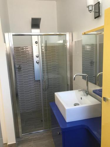 y baño con lavabo y ducha acristalada. en Arôme Marin, en Le Marin