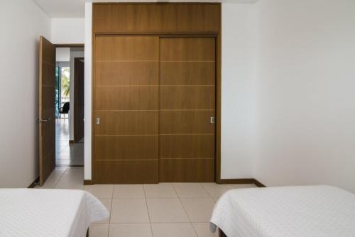 1 dormitorio con 2 camas y armario de madera en Magico Apartamento Frente al Mar 2 Habitaciones PAZ124, en Coveñas