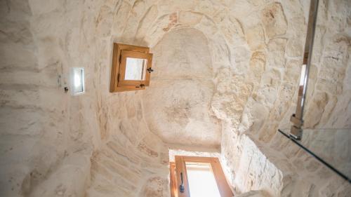 uma casa de banho com uma parede de pedra e uma janela em Astra em Alberobello