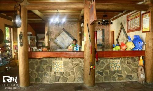 a man sitting at a bar in a restaurant at Pousada Taruma in Mucuri