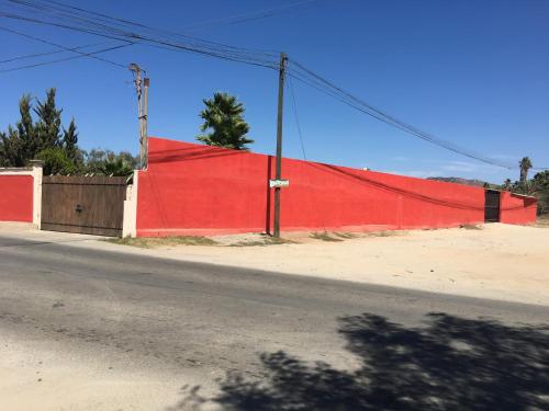 a red wall on the side of a road at Cabaña R y A Valle de Guadalupe in Valle de Guadalupe