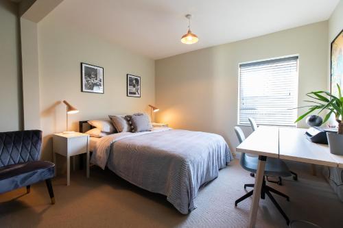 a bedroom with a bed and a table and a desk at Unique Central Town House in Norwich