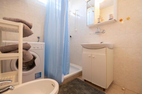 a bathroom with a washing machine and a sink at Apartment Ksenija in Ljubljana