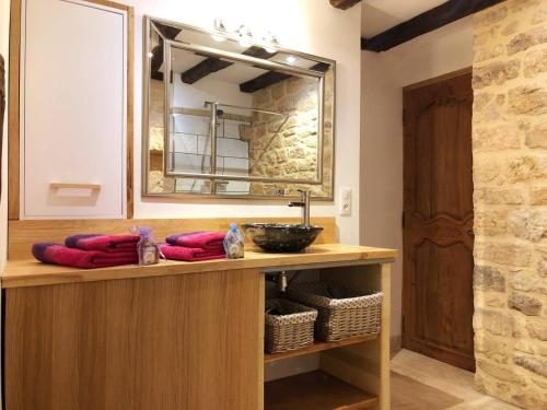 a bathroom with a counter with a sink and a mirror at Les Arcades in Sarlat-la-Canéda