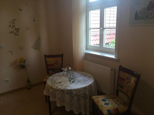 a dining room with a table and two chairs and a window at Alte Schule Niederdünzebach in Eschwege