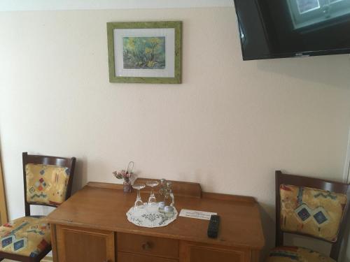 a dining room table with two chairs and a table and a picture at Alte Schule Niederdünzebach in Eschwege