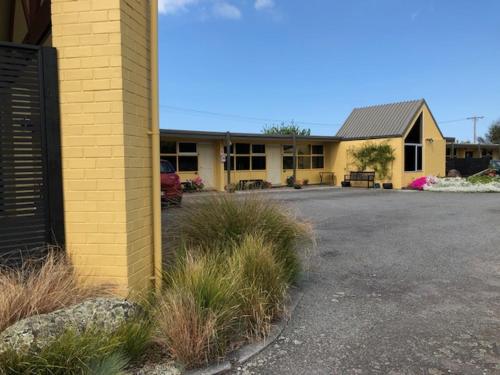 a building with a parking lot in front of it at Mount View Motel Hawera in Hawera