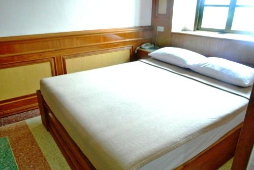 a bed with two pillows on it in a room at Rose Garden Hotel in Phra Nakhon Si Ayutthaya