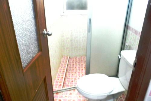 a small bathroom with a toilet and a shower at Rose Garden Hotel in Phra Nakhon Si Ayutthaya