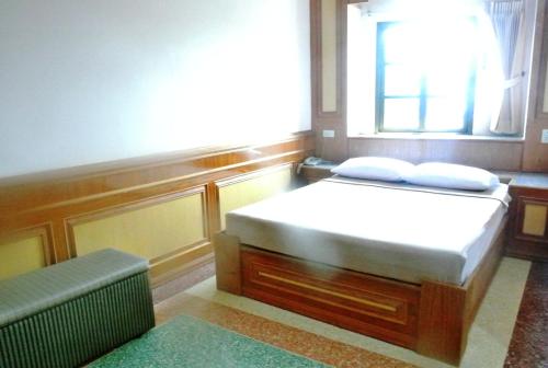 a small bedroom with a bed and a window at Rose Garden Hotel in Phra Nakhon Si Ayutthaya