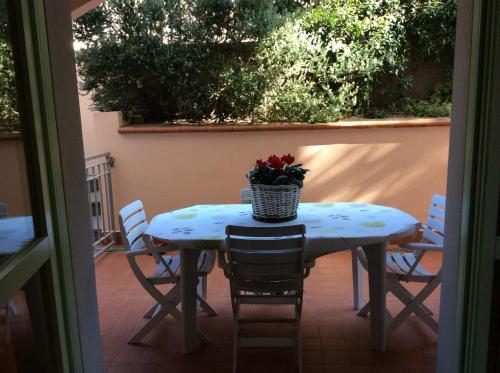 stół z krzesłami i kosz kwiatów w obiekcie Il Mare w mieście San Vincenzo