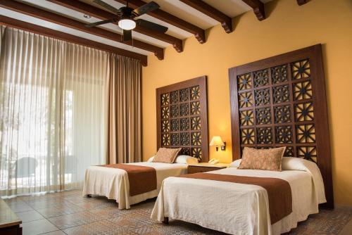 a hotel room with two beds and a window at TecnoHotel Valladolid in Valladolid