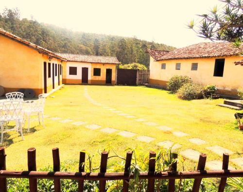 een tuin met een hek en twee gebouwen bij Pousada Fazenda São Luiz in São Luiz do Paraitinga
