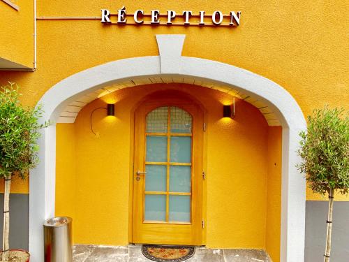 a yellow building with a door on the side of it at Hotel Adore in Romanel-sur-Lausanne
