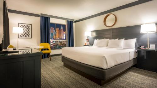 a hotel room with a bed and a desk and a window at OYO Hotel and Casino Las Vegas in Las Vegas