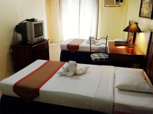 a hotel room with two beds with a stuffed animal on the bed at Crown Regency Residences Davao in Davao City