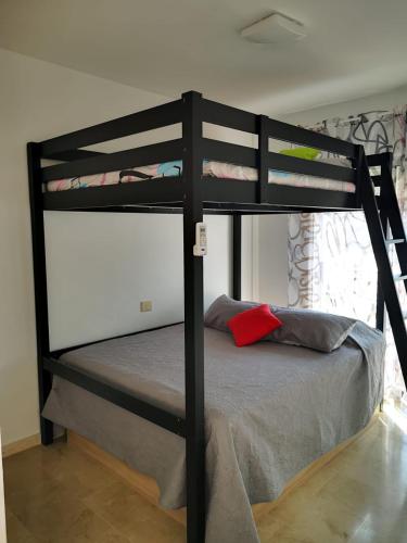 a black bunk bed with a red pillow on it at Beautiful duplex with jacuzzi in Puerto Rico de Gran Canaria