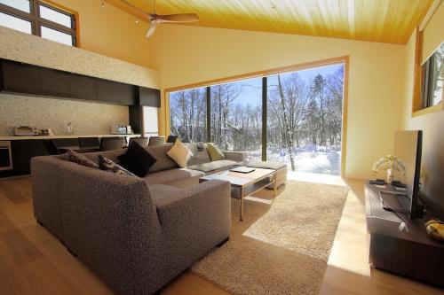 a living room with a couch and a table at SOLAR CHALETS by Hakuba Hotel Group in Hakuba