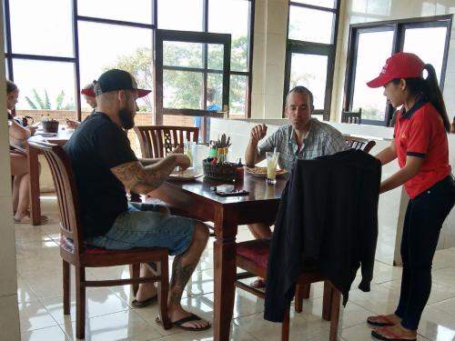 a group of people sitting at a table in a restaurant at Volcano Living in Kintamani