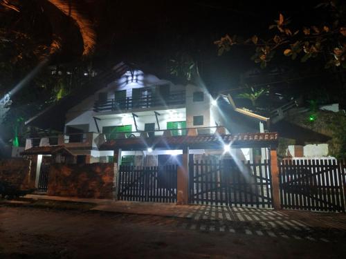 una casa con luces delante de ella por la noche en Encontro dos Mares Chalés Lázaro, en Ubatuba