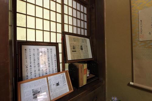 een venster met twee ingelijste foto's op een plank bij Yoshinoonsen Motoyu in Yoshino