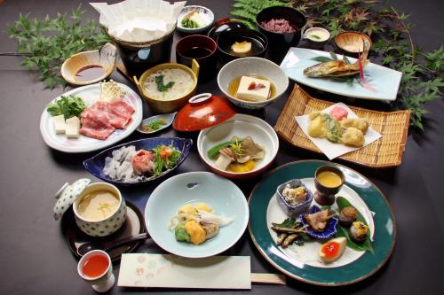 een tafel met veel borden eten erop bij Yoshinoonsen Motoyu in Yoshino