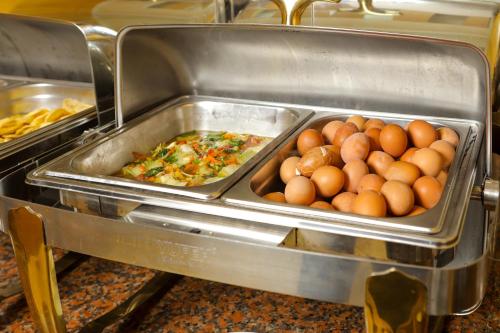 a tray of eggs and other food in a restaurant at First Eden Hotel - Hang Bun in Hanoi