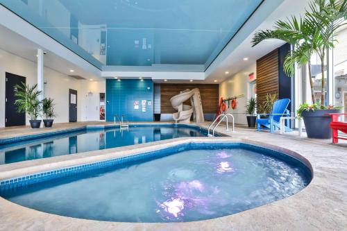 a large swimming pool with a slide in a house at Comfort Inn & Suites in Saint-Jérôme