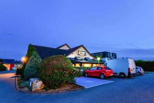 a car parked in a parking lot next to a house at Comfort Hotel Evreux in Évreux